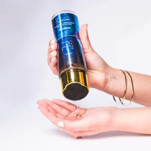 "Hand pouring shimmering body wash from bottle."